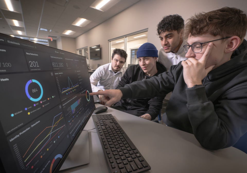 four students review an interactive dashboard