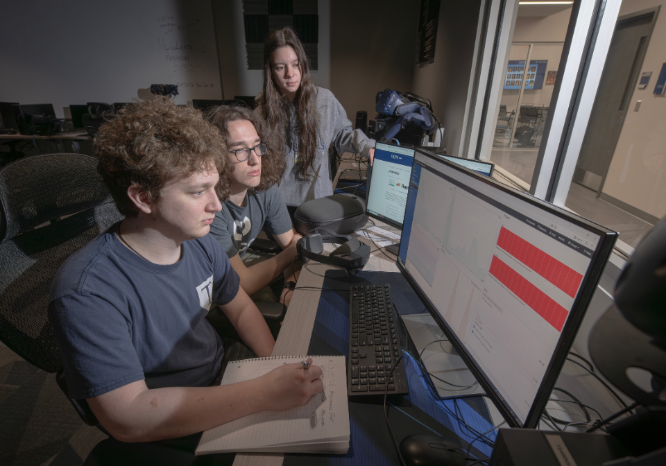 three students view results of medical trainer