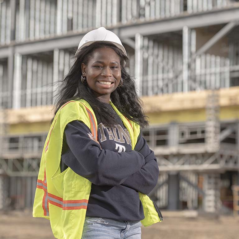 Student in front of building under construction