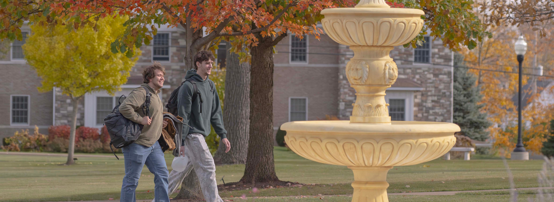 two students laughing outside near trine's fountain