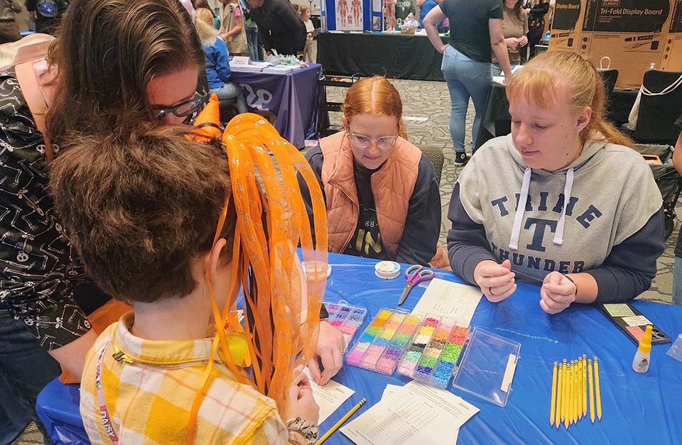 Trine students with Girl Scout at STEM Expo