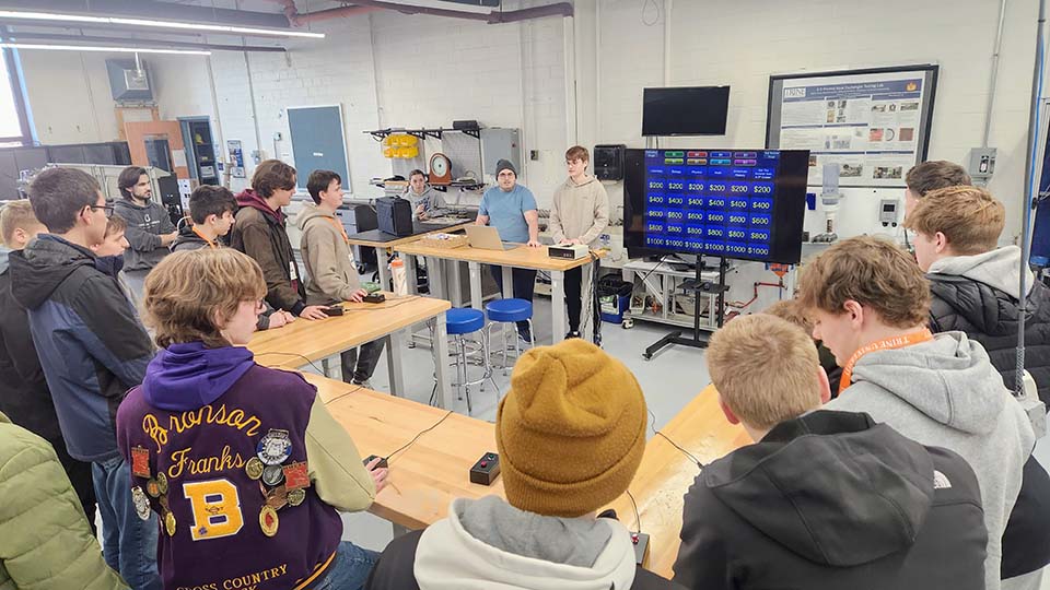 Students in lab area with Jeopardy board