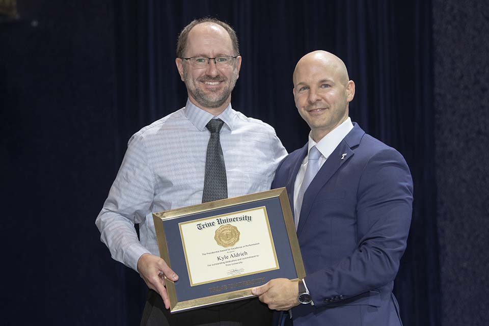 Kyle Aldrich receiving framed certificate from Dr. Tony Kline