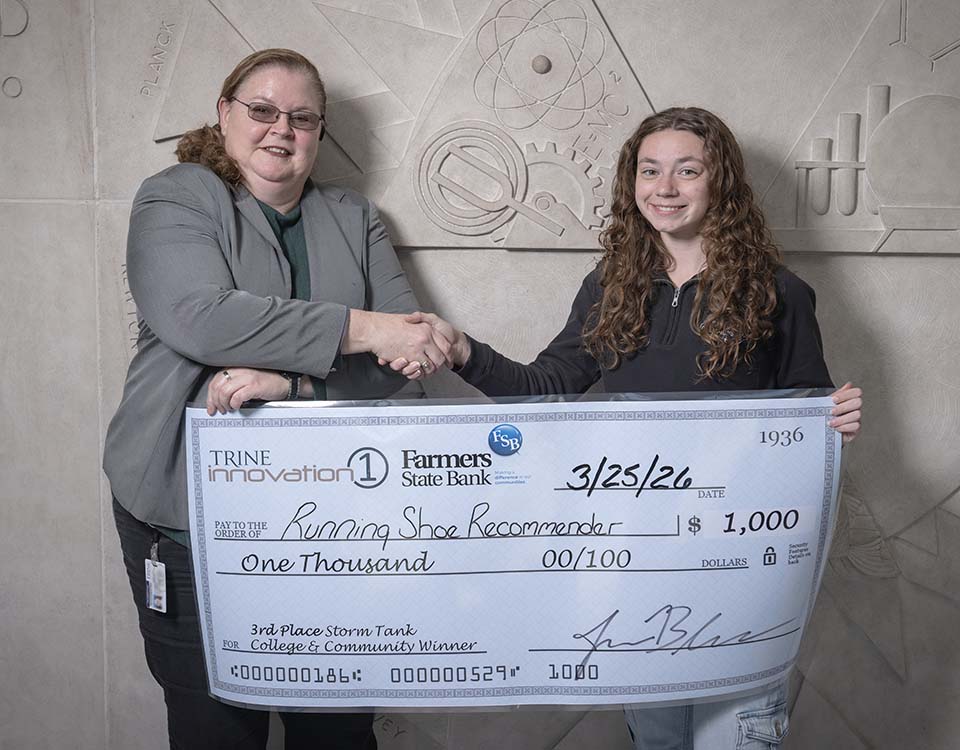 College administrator presenting large check to student