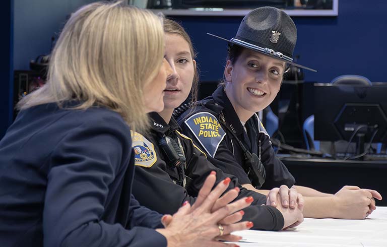 Three women who work in criminal justice sitting at a table speaking